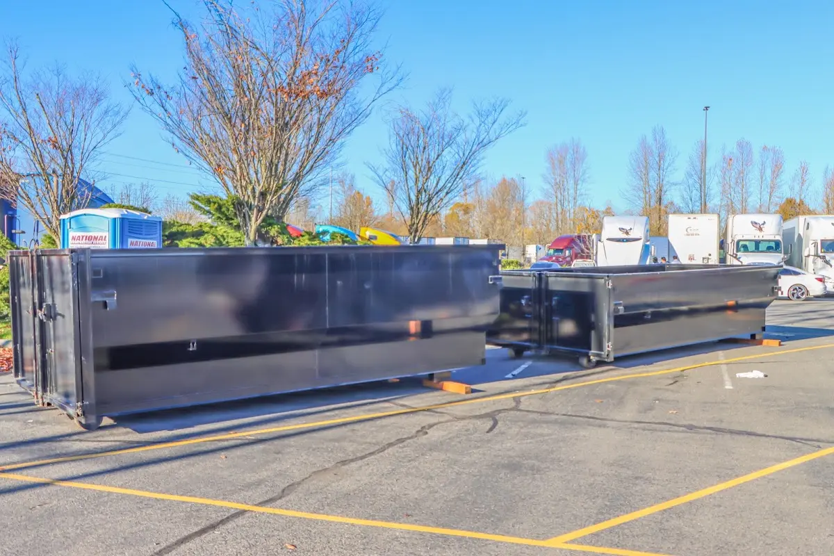 Professional dumpster rental service with roll-off container on residential driveway in Polson